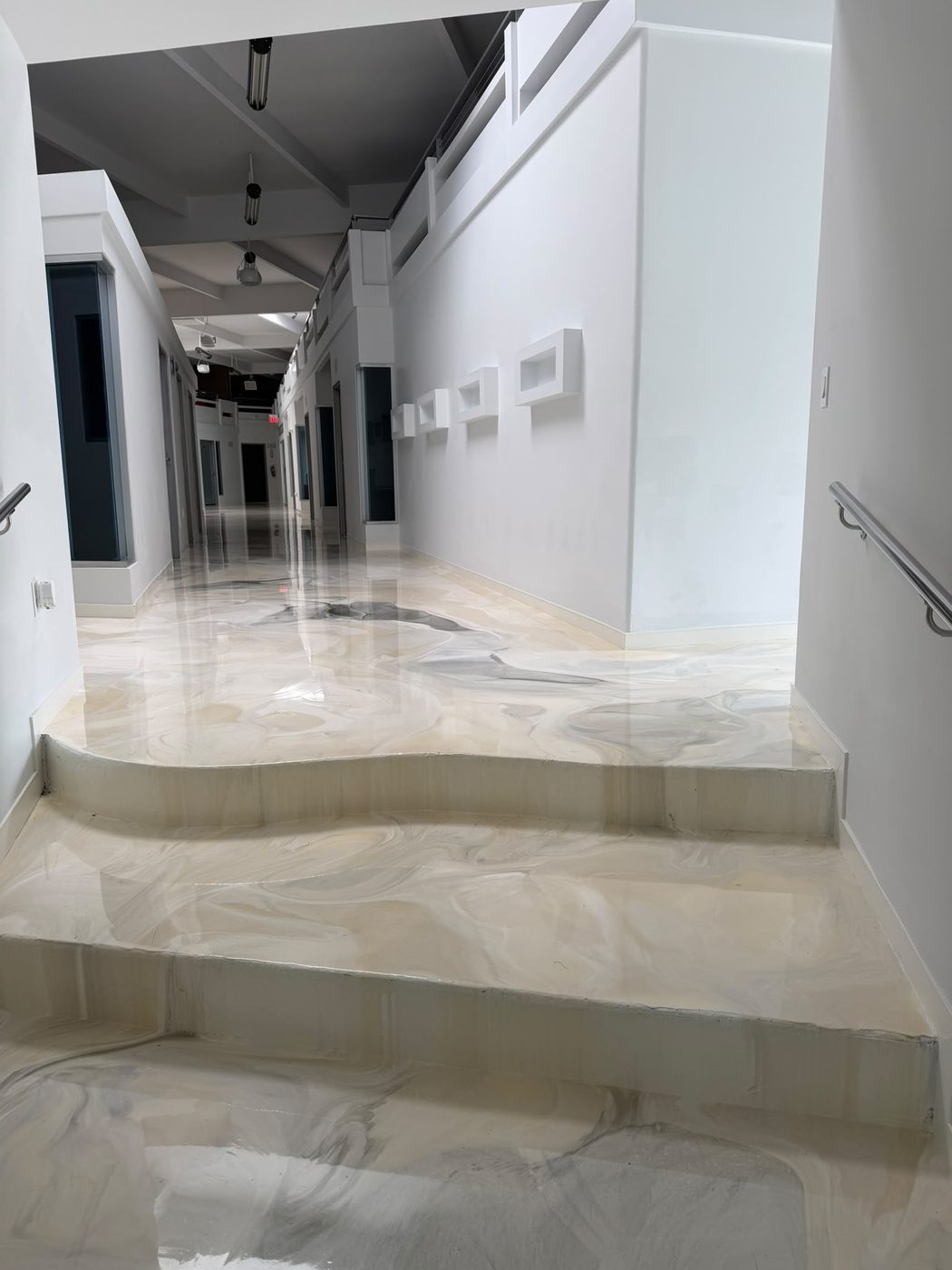 Escalinata escultural con piso de resina perlada