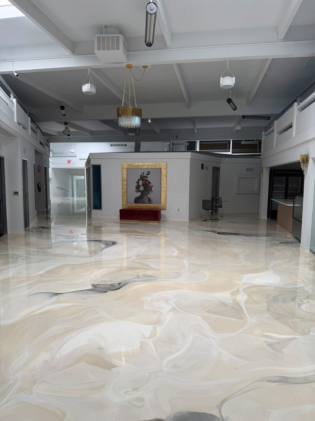 Galería con candelabro dorado, retrato enmarcado y banca de terciopelo
