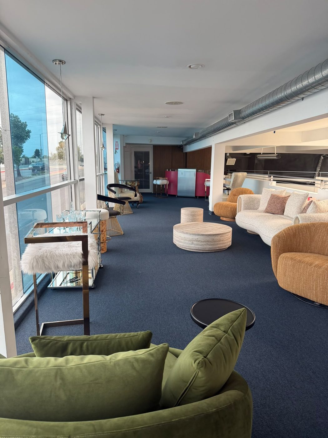 Área lounge con sillones de terciopelo y carrito de bar